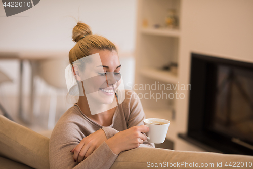 Image of woman with a mug near a fireplace