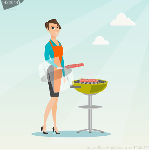 Image of Woman cooking steak on barbecue grill.