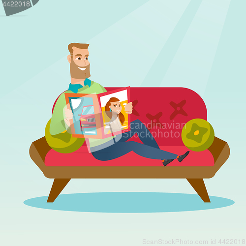 Image of Man reading a magazine on the couch.