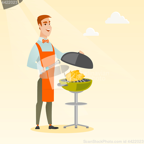 Image of Man cooking chicken on barbecue grill.
