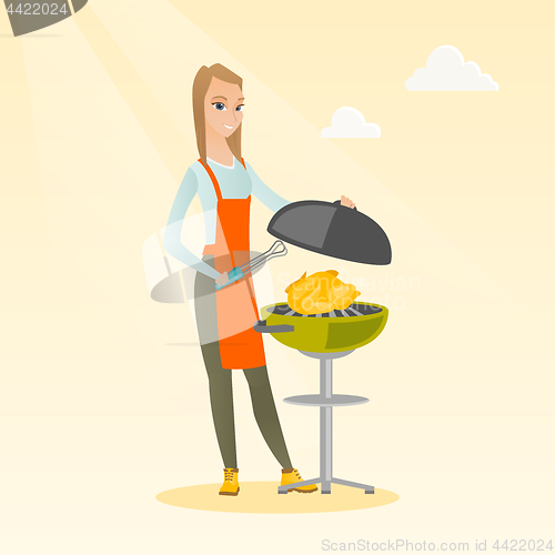 Image of Woman cooking chicken on barbecue grill.