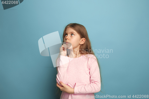 Image of The thoughtful girl. Teen girl on a blue background. Facial expressions and people emotions concept