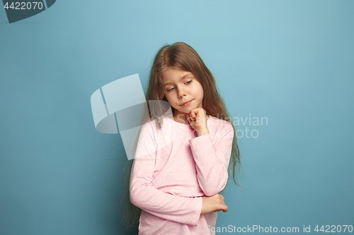 Image of The thoughtful girl. Teen girl on a blue background. Facial expressions and people emotions concept