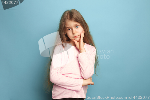 Image of The thoughtful girl. Teen girl on a blue background. Facial expressions and people emotions concept