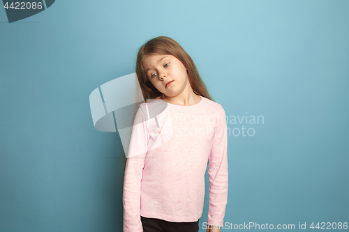 Image of The thoughtful girl. Teen girl on a blue background. Facial expressions and people emotions concept