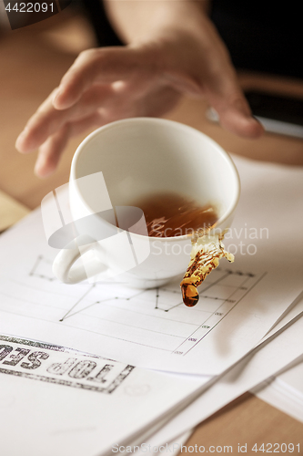 Image of Coffee in white cup spilling on the table in the morning working day at office table