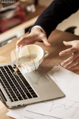 Image of Coffee in white cup spilling on the table in the morning working day at office table