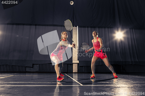 Image of Young women playing badminton at gym