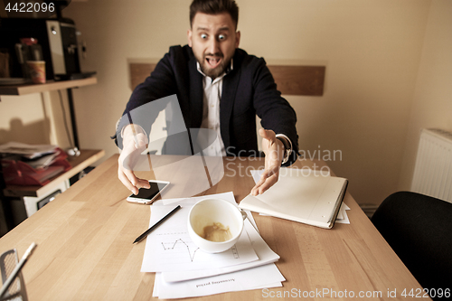 Image of Coffee in white cup spilling on the table in the morning working day at office table