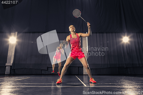 Image of Young women playing badminton at gym