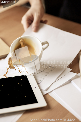 Image of Coffee in white cup spilling on the table in the morning working day at office table