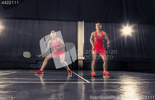 Image of Young women playing badminton at gym