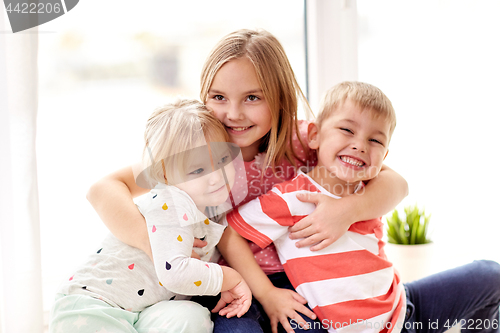 Image of happy little kids hugging at window