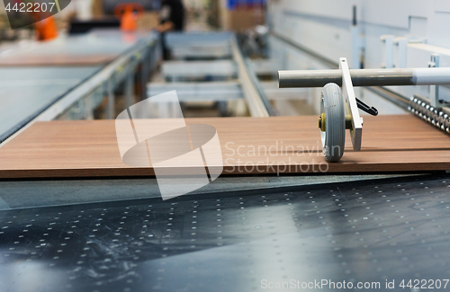 Image of wooden board on conveyer at furniture factory