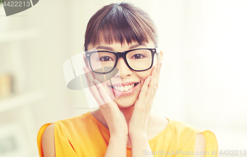 Image of happy asian young woman in glasses at home