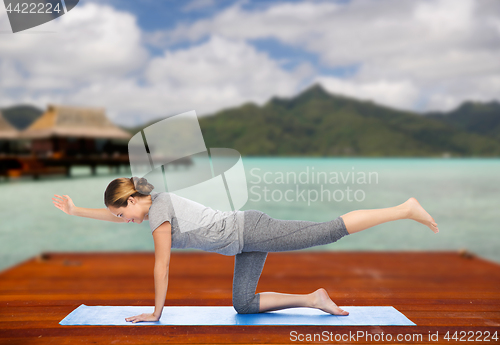 Image of woman making yoga in balancing table pose outdoors