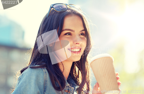 Image of happy young woman drinking coffee on city street