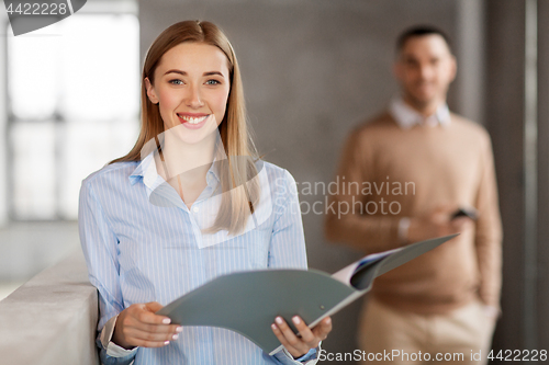 Image of smiling female office worker with folder