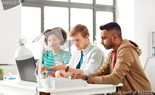 Image of happy creative workers with laptops at office