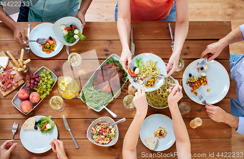 Image of group of people eating at table with food