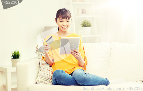 Image of happy asian woman with tablet pc and credit card