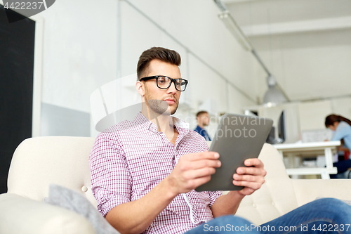 Image of man in glasses with tablet pc working at office