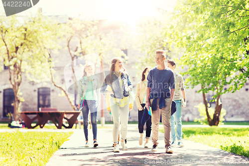 Image of group of happy teenage students walking outdoors