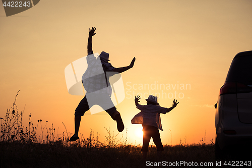 Image of Father and son playing in the park at the sunset time.