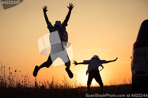 Image of Father and son playing in the park at the sunset time.