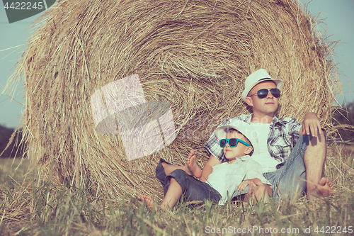 Image of Father and son playing in the park at the day time.