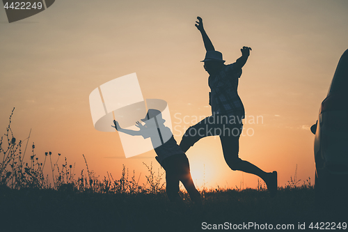 Image of Father and son playing in the park at the sunset time.