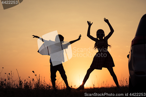 Image of Happy children playing in the park at the sunset time.