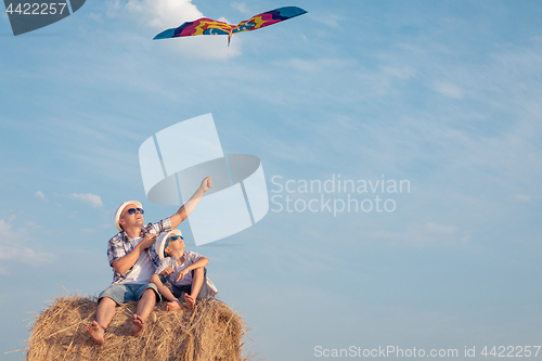 Image of Father and son playing in the park at the day time.