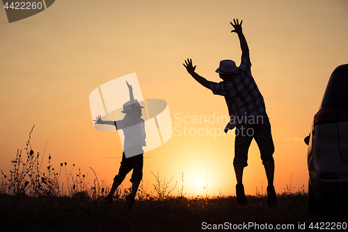 Image of Father and son playing in the park at the sunset time.