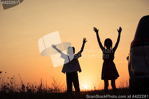 Image of Happy children playing in the park at the sunset time.