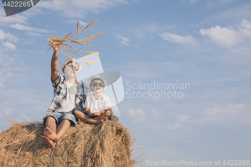 Image of Father and son playing in the park at the day time.