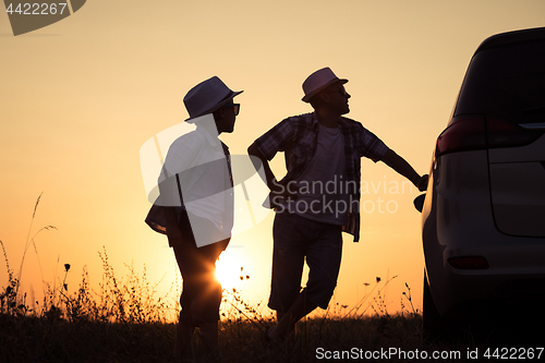 Image of Father and son playing in the park at the sunset time.