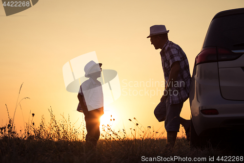 Image of Father and son playing in the park at the sunset time.