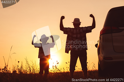 Image of Father and son playing in the park at the sunset time.