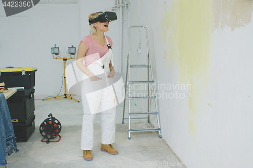 Image of Excited female painter in virtual reality goggles 