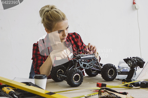 Image of Female repairing radio-controlled car 