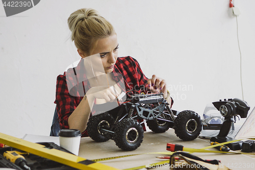 Image of Female repairing radio-controlled car 