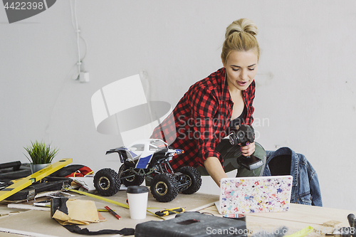 Image of Female with radio-controlled car using laptop