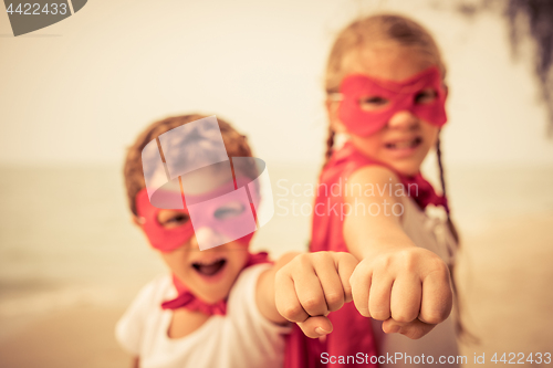 Image of Two happy little children playing on the beach at the day time.