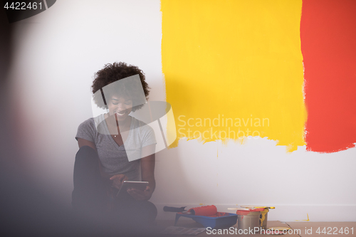 Image of back female painter sitting on floor