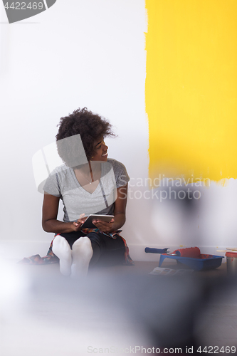 Image of back female painter sitting on floor