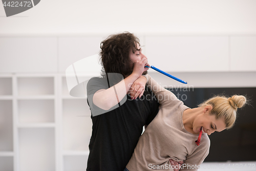 Image of couple in party hats blowing in whistle