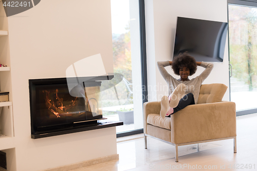 Image of black woman in front of fireplace