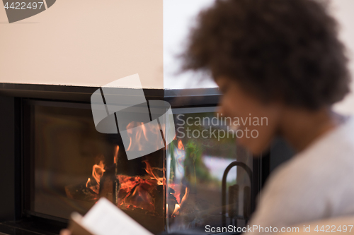 Image of black woman at home reading book