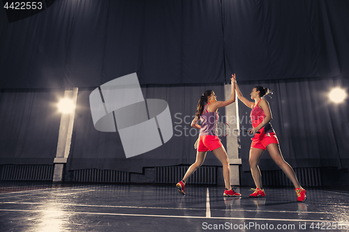 Image of Young women playing badminton at gym